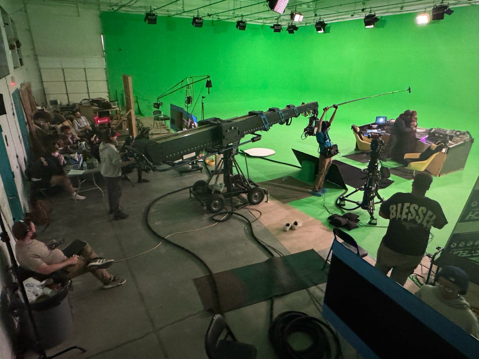 Overhead view of the ABQ Castle Studios stage during Mr. Spaceship, with the camera crane, a boom operator and a picture vehicle in frame