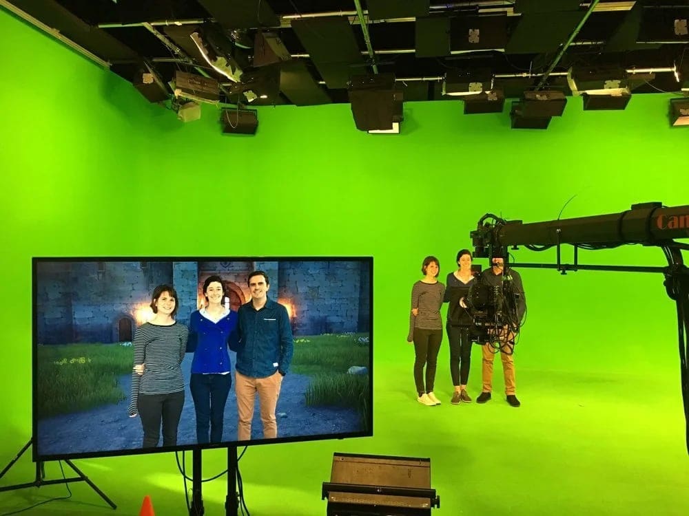 Talent on the Burbank green screen stage with the live virtual set composite on the monitor