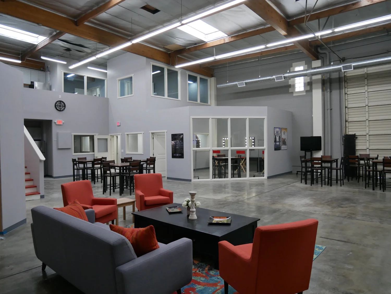 Burbank office space for lease: lounge seating and a glass-walled makeup room in the L.A. Castle Studios production offices, beneath high beamed ceilings.