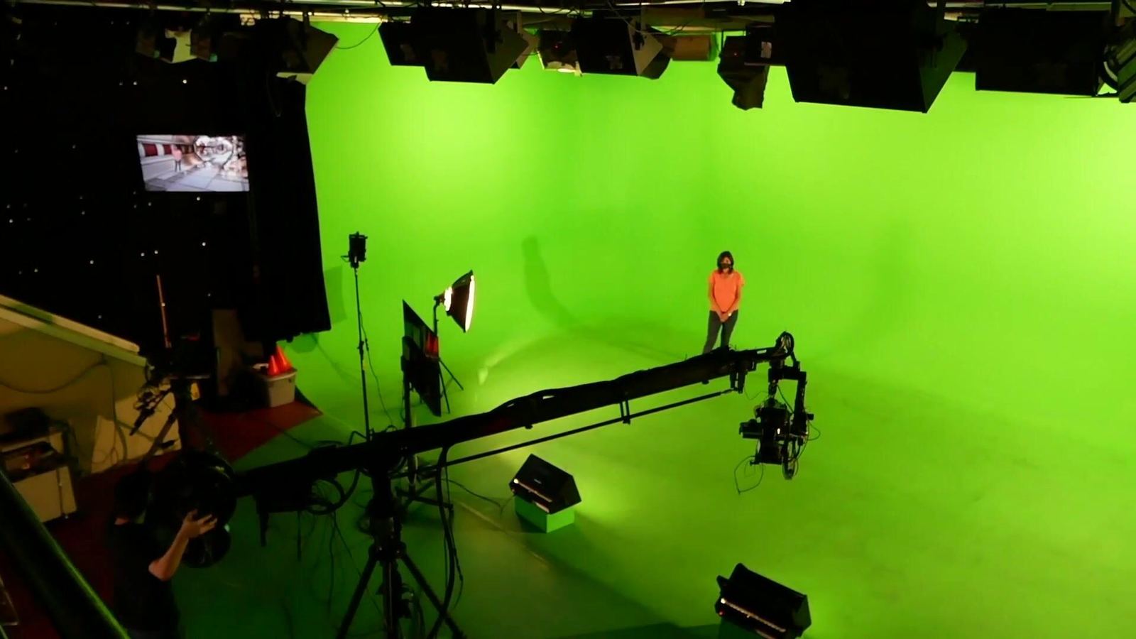 Green screen studio in Burbank: a camera jib and lights on the pre-lit cyclorama, with the live chroma key composite on the monitor