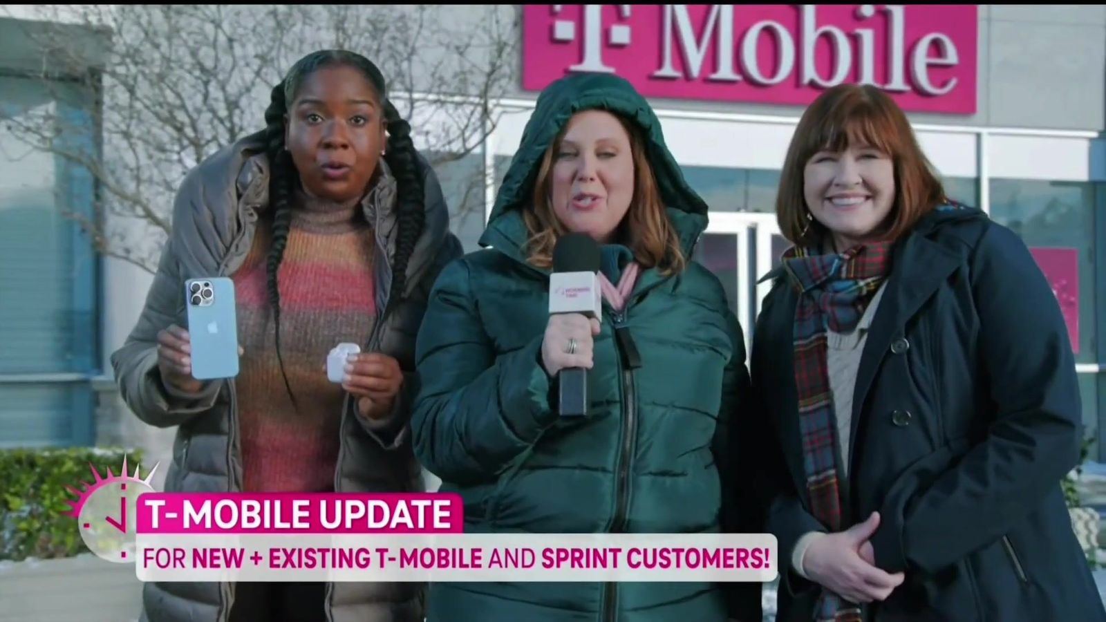 Three presenters in winter coats in front of a T-Mobile storefront, from a T-Mobile update spot at L.A. & ABQ Castle Studios
