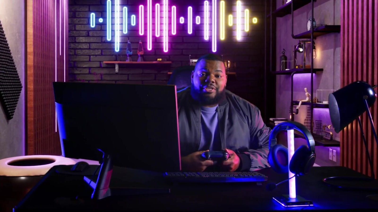 Commercial: a gamer with a controller at a desk in a neon-lit streaming room with a sound-wave light sign, a virtual set at L.A. & ABQ Castle Studios