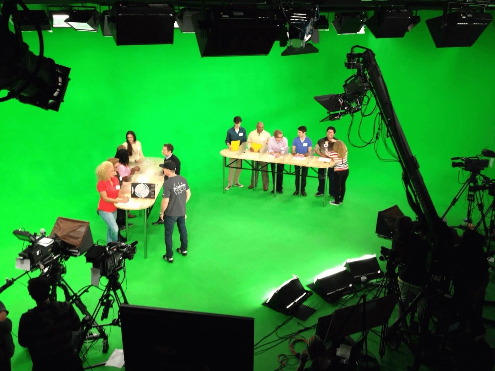 Game show production — overhead view of contestants at quiz tables on a green screen stage surrounded by cameras, jib arm and studio lights at L.A. & ABQ Castle Studios