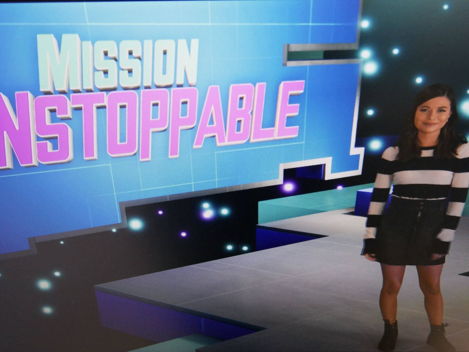 Host wrap: a presenter beside the 'Mission Unstoppable' title graphic on a colorful virtual set, a live in-camera composite at L.A. & ABQ Castle Studios