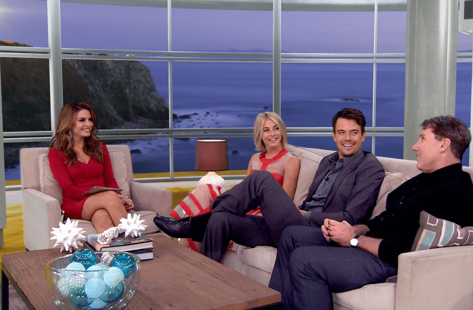 Talk show set: host and three guests laughing on white couches before an ocean-cliff window view, a virtual production set at L.A. & ABQ Castle Studios