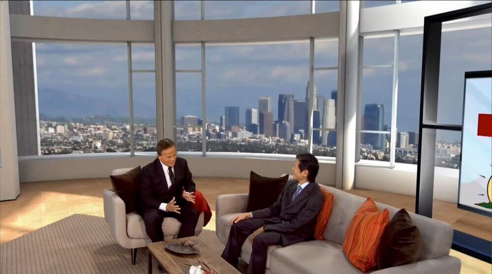 Talk show set: host and guest in gray armchairs before a panoramic downtown L.A. skyline window, a virtual production set at L.A. & ABQ Castle Studios