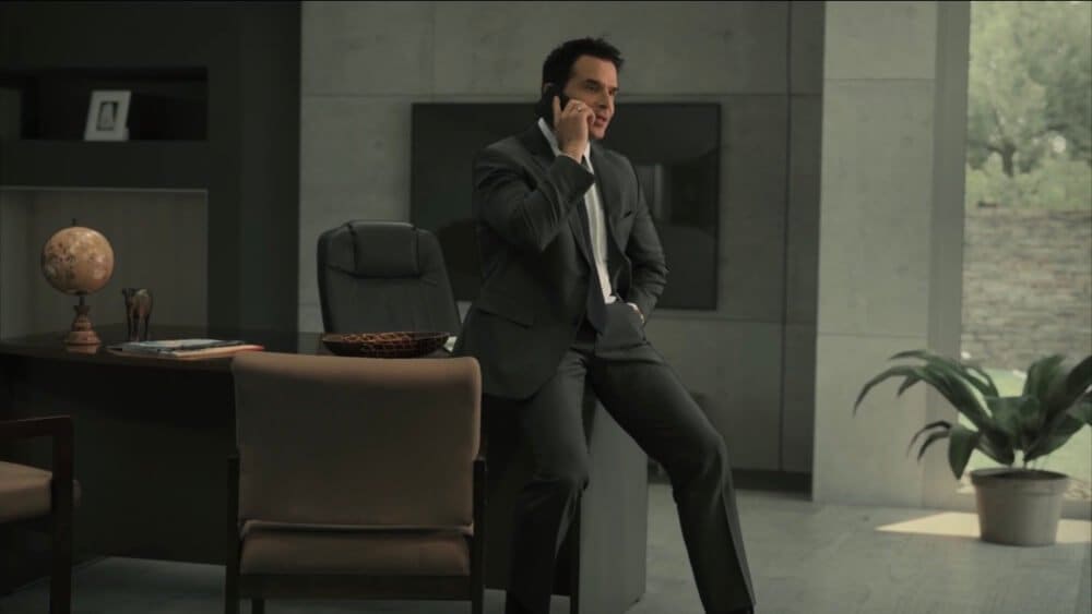 TV and film set — an actor in a suit on the phone in a sleek modern concrete office, a virtual production set at L.A. & ABQ Castle Studios