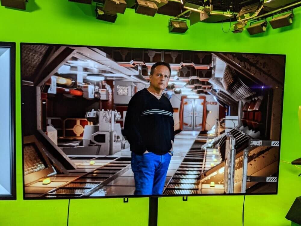 An actor on the green screen floor, seen on the monitor inside a live spaceship-interior composite, at L.A. Castle Studios